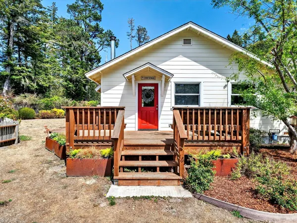 a view of a house with wooden deck front of house