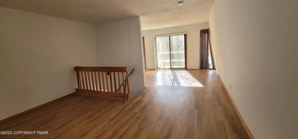 a view of a room with wooden floor and a window