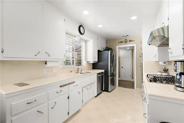 a kitchen with cabinets and stainless steel appliances