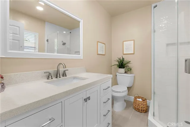 a bathroom with a granite countertop sink a toilet and a mirror