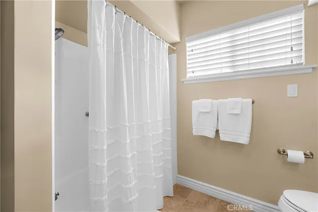 a bathroom with a shower curtain and a window