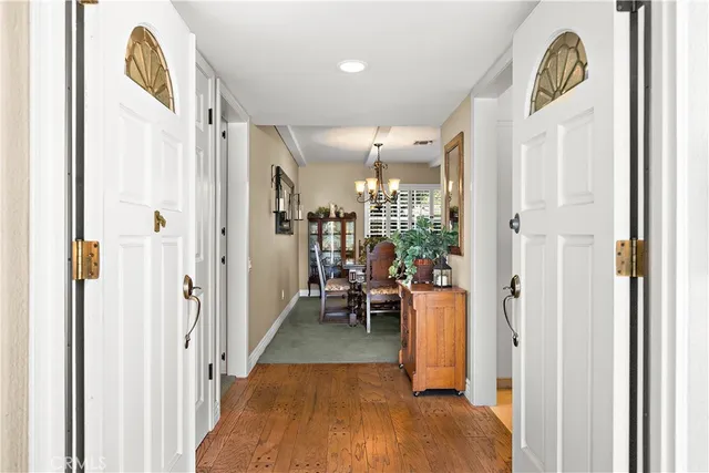 a view of a hallway with dining area and chandelier