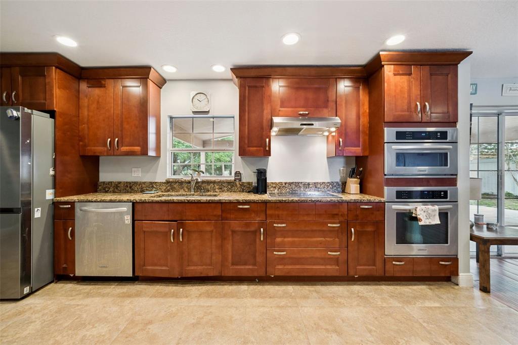 1050 Crystal Bowl Circle Casselberry, FL 32707 - Photo 14 of 64 a kitchen with granite countertop a refrigerator and a stove top oven