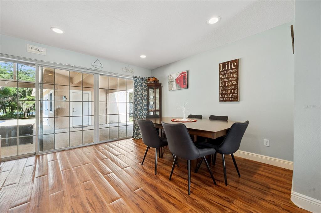 1050 Crystal Bowl Circle Casselberry, FL 32707 - Photo 8 of 64 a view of a dining room with furniture and wooden floor