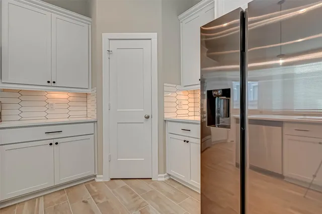 a view of kitchen with refrigerator cabinets and table