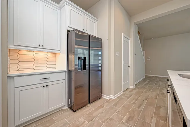 a view of kitchen with refrigerator and window