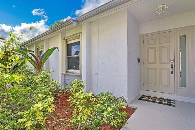 a view of yellow house with potted plants