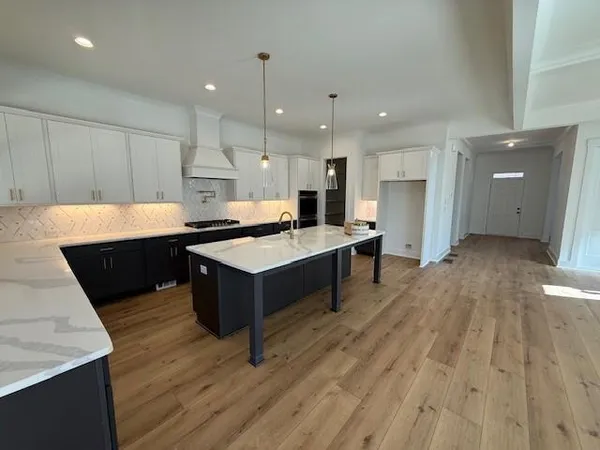 a large kitchen with kitchen island a sink stainless steel appliances and cabinets