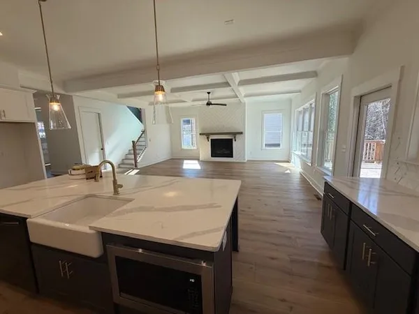 a kitchen with a sink a counter space and wooden floor