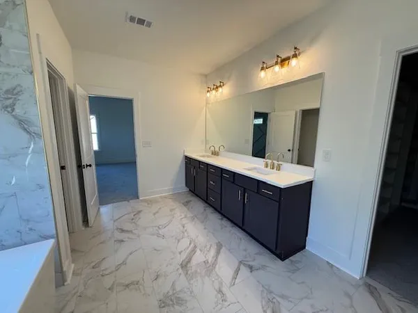 a bathroom with a double vanity sink and mirror