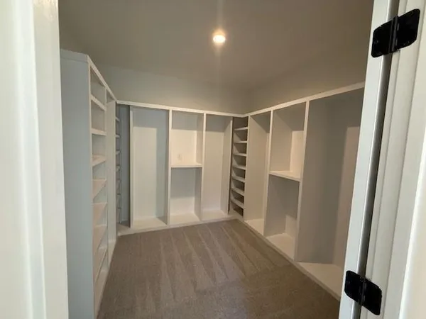 a view of walk in closet with wooden floor