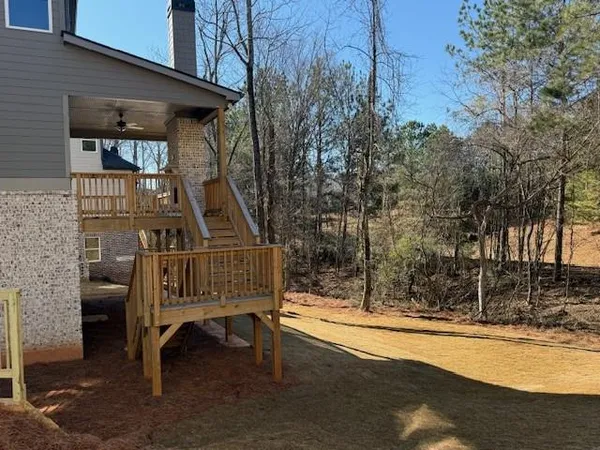 a view of a roof deck with couches and wooden fence