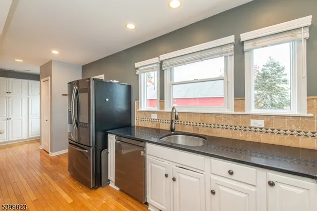 a kitchen with granite countertop a refrigerator and a sink