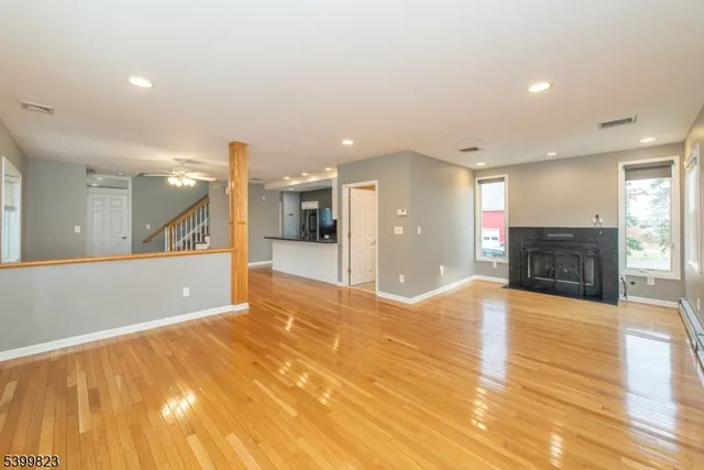a view of large hall with stainless steel appliances granite countertop cabinets and fireplace