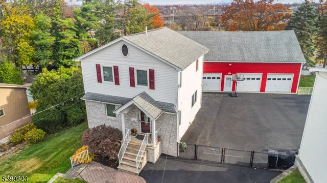 a aerial view of a house with a yard plants and large tree
