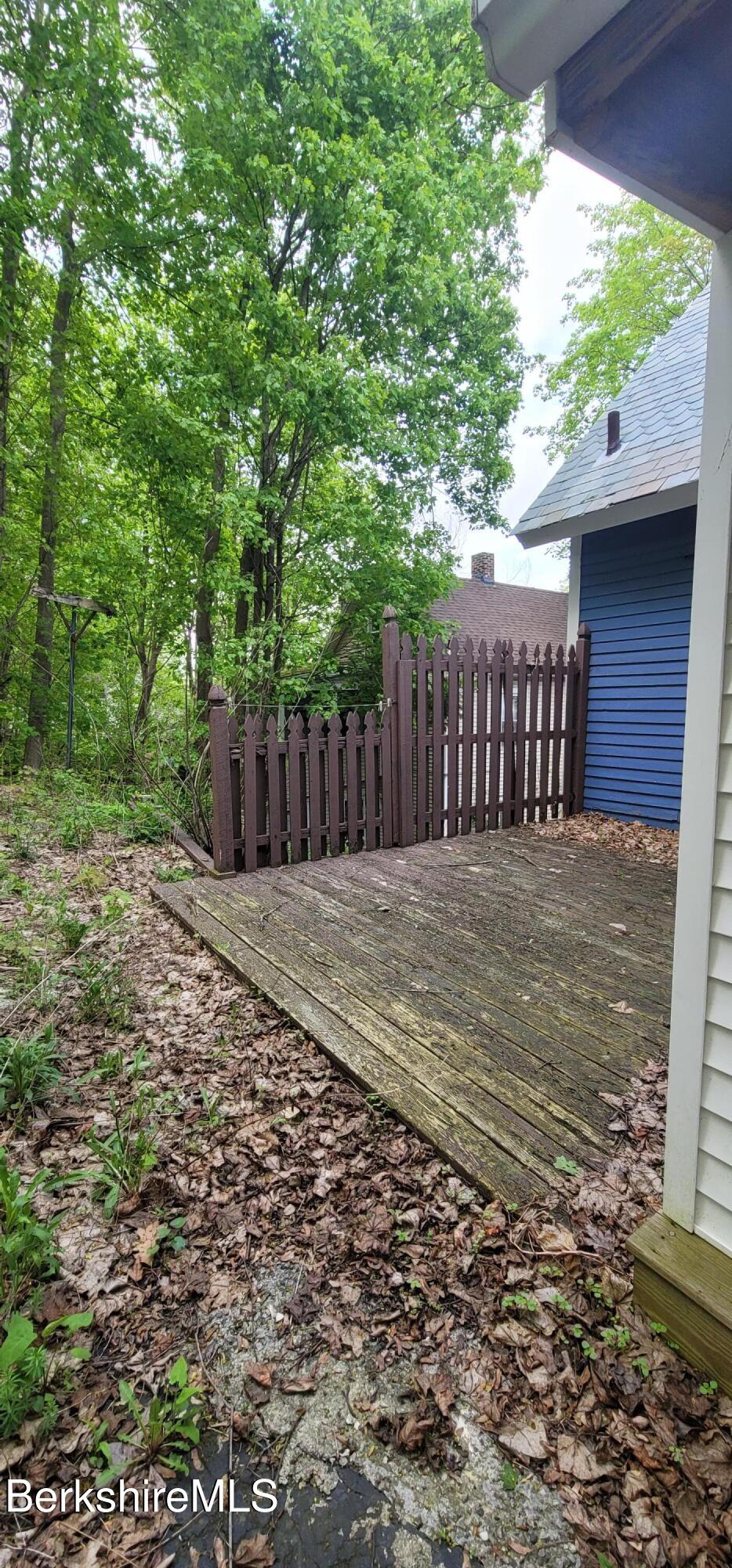 301 Walnut Street North Adams, MA 01247 - Photo 2 of 12 a view of a backyard with large trees and wooden fence