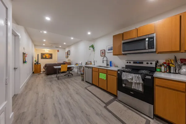 a kitchen with furniture wooden floor and stainless steel appliances