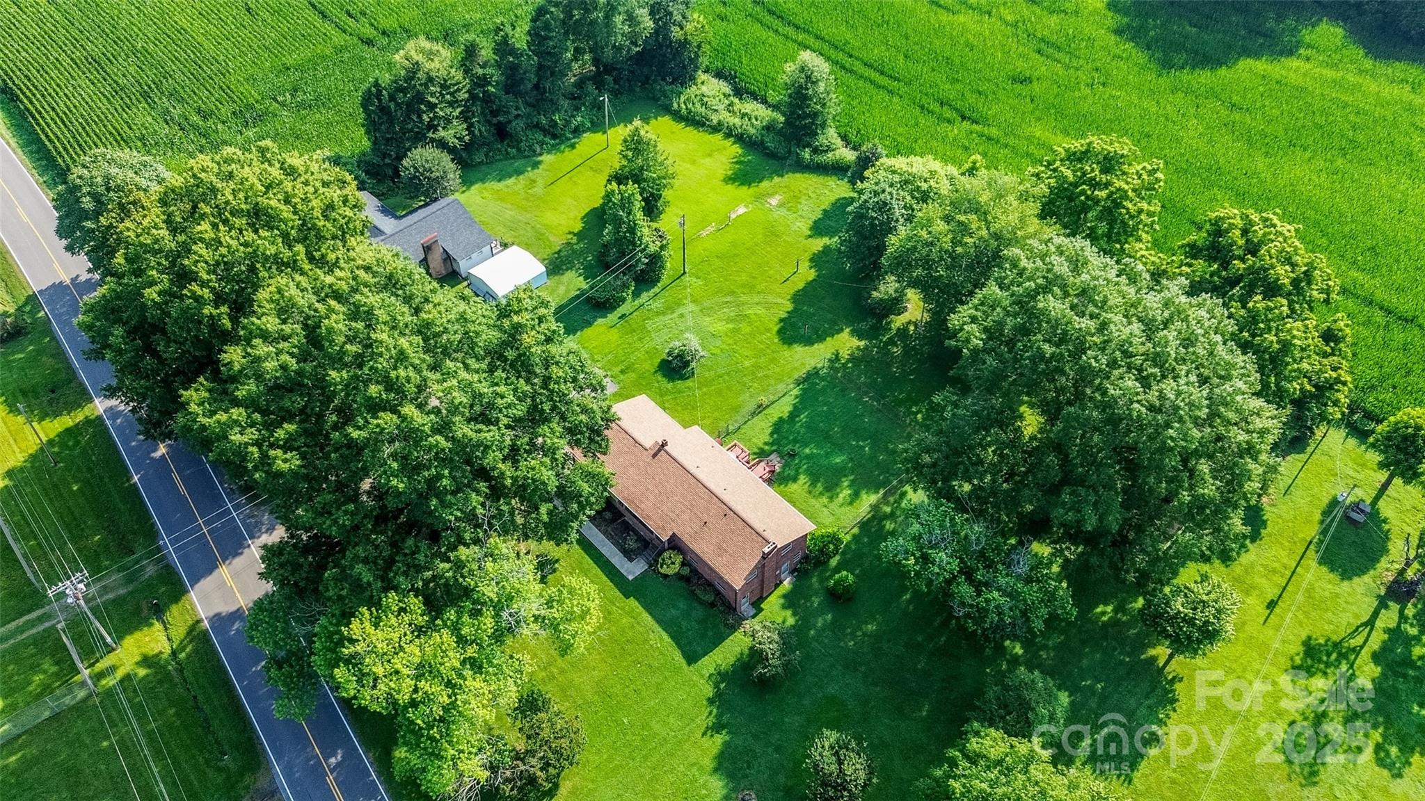 an aerial view of a house with swimming pool and green space