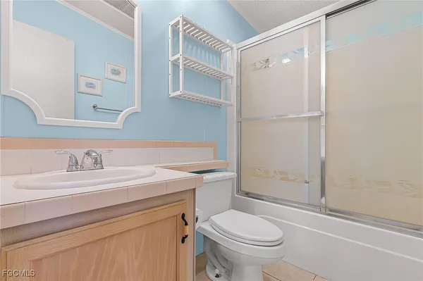 a bathroom with a sink toilet vanity and shower