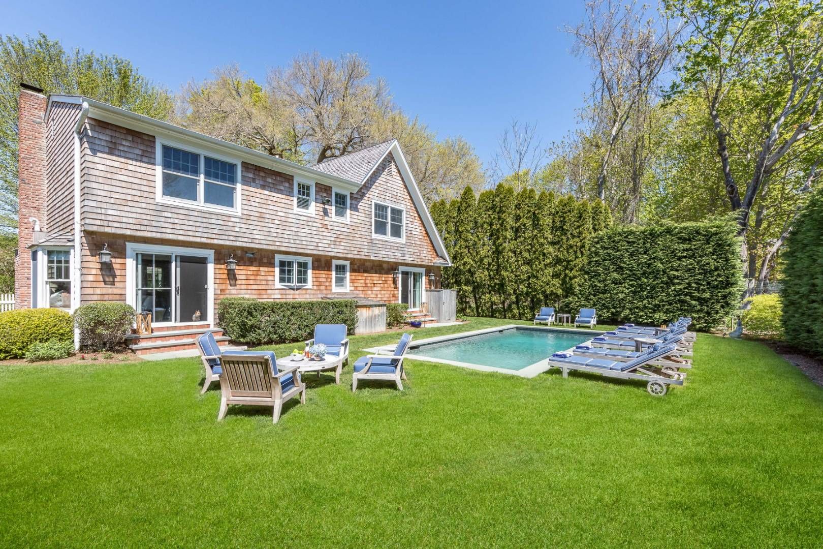 34 Sherrill Road East Hampton, NY 11937 - Photo 20 of 21 a front view of a house with a yard table and chairs