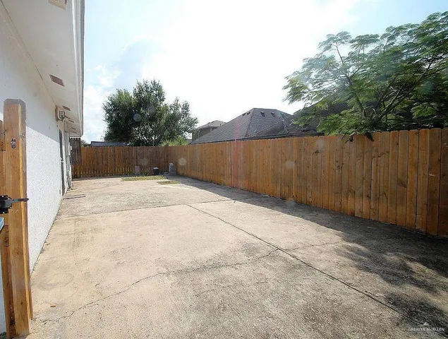 a view of backyard with potted plants and wooden fence