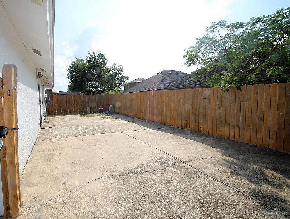 3738 Rey David Drive Brownsville, TX 78521 - Photo 11 of 12 a view of backyard with potted plants and wooden fence