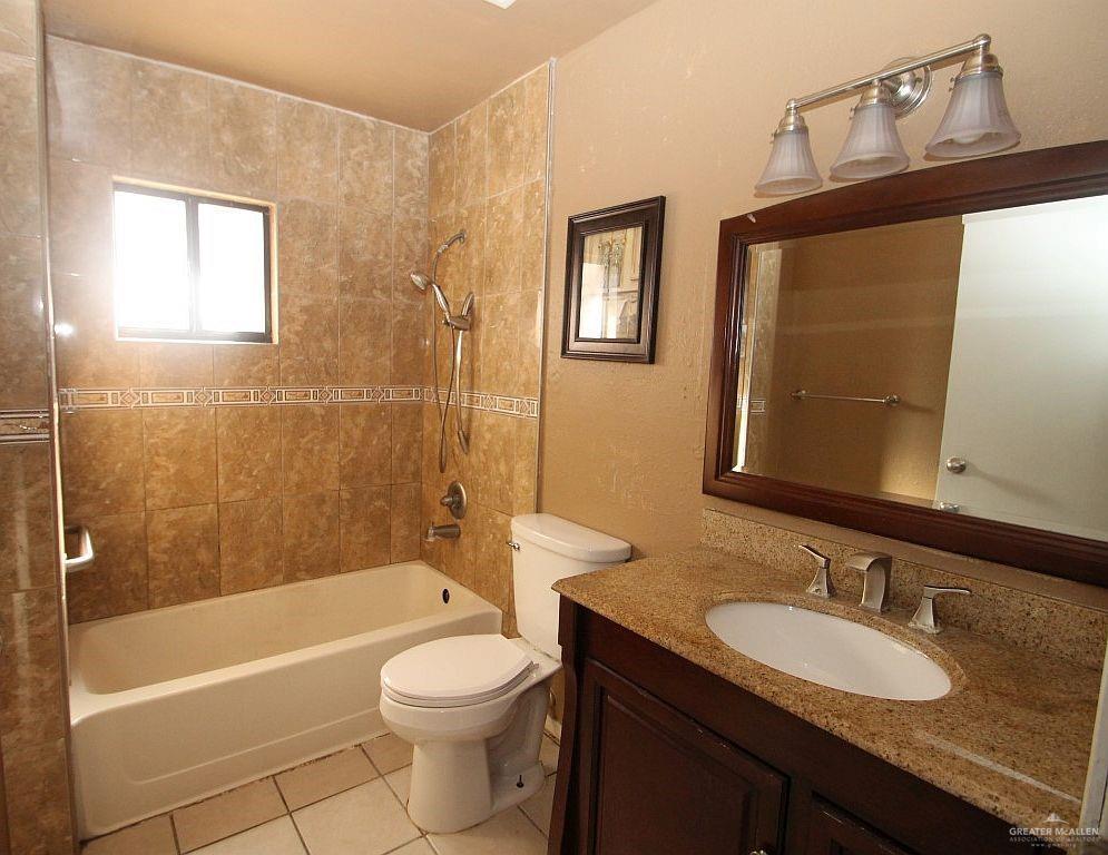 3738 Rey David Drive Brownsville, TX 78521 - Photo 4 of 12 a bathroom with a granite countertop toilet a sink and bathtub