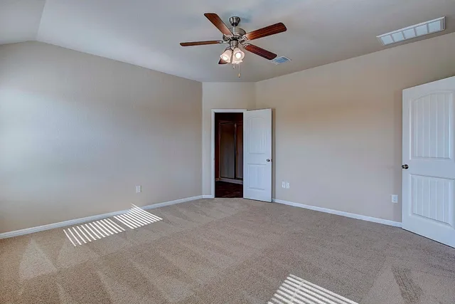 a view of an empty room with a ceiling fan