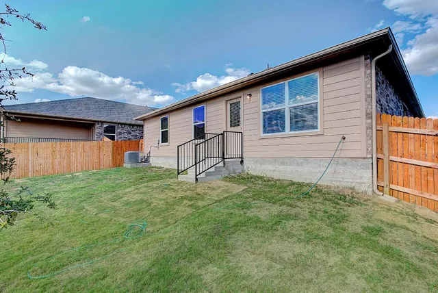 a backyard of a house with table and chairs