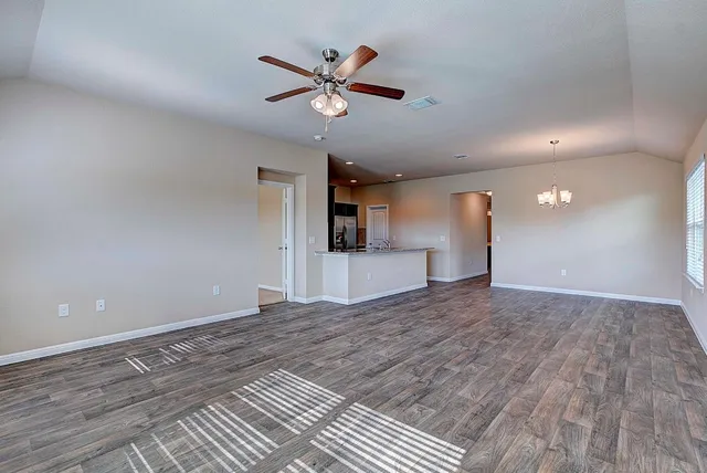 a view of empty room with wooden floor and ceiling fan