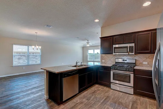 a kitchen with granite countertop stainless steel appliances and wooden cabinets