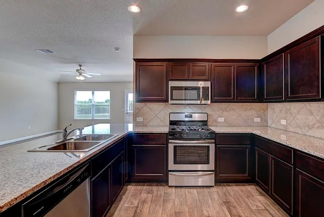 a kitchen with a sink stove top oven and cabinets
