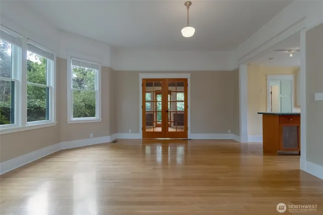 a view of empty room with wooden floor and fan