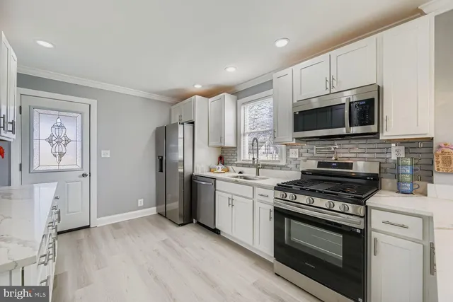 a kitchen with stainless steel appliances a stove microwave and a refrigerator
