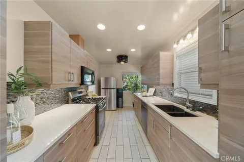 a kitchen with stainless steel appliances kitchen island granite countertop a sink and stove top oven