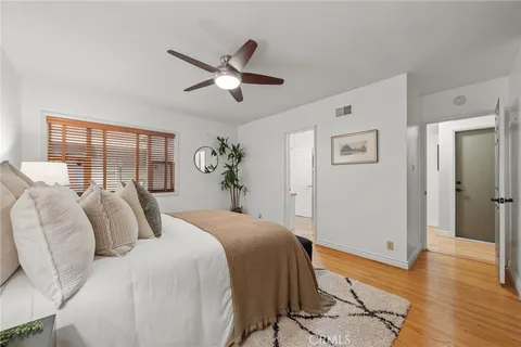 a bedroom with a large bed and wooden floor
