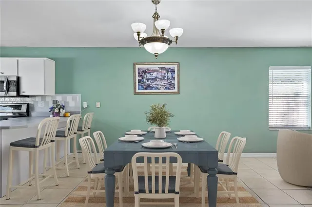 a view of a dining room with furniture a chandelier and wooden floor