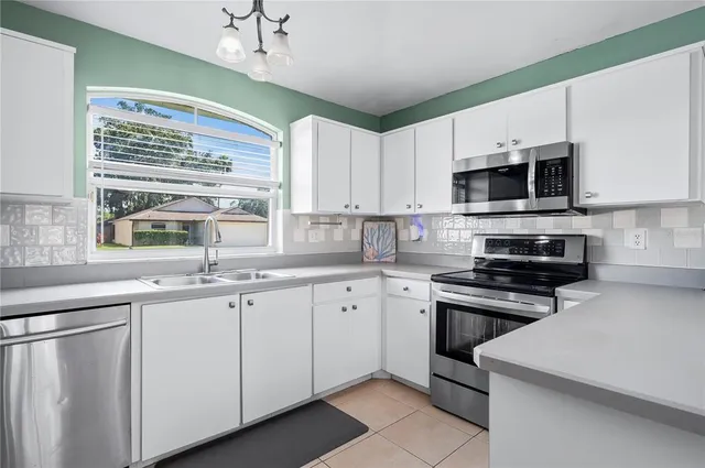 a kitchen with a refrigerator sink and cabinets