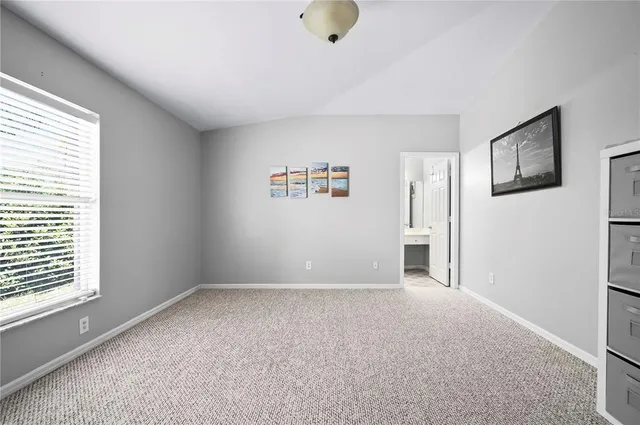 a spacious bedroom with a large bed and windows