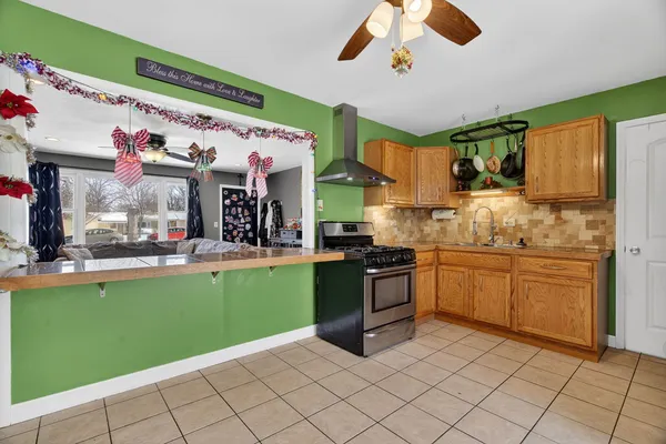 a kitchen with a refrigerator a sink dishwasher a dining table and chairs with wooden floor
