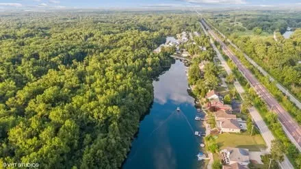 an aerial view of a house with a yard and lake view