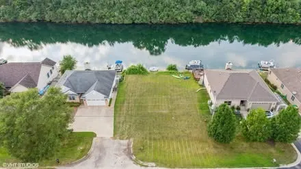 an aerial view of a house with a yard and lake view