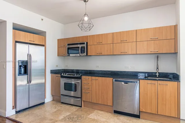 a kitchen with stainless steel appliances granite countertop a stove and a refrigerator