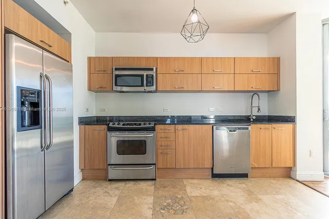 a kitchen with stainless steel appliances granite countertop a stove a microwave and a refrigerator