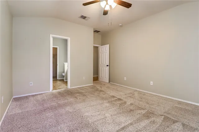 a view of an empty room with a chandelier fan
