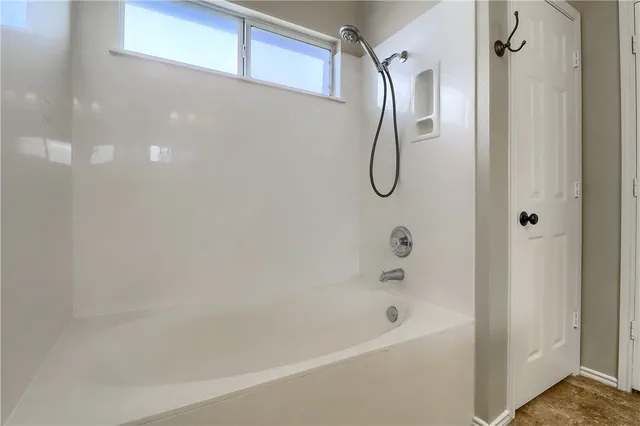a bathroom with a bath tub with a shower
