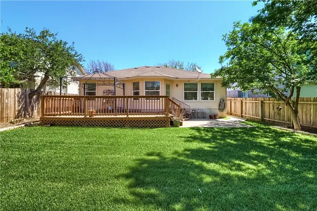 a view of a house with backyard and a tree