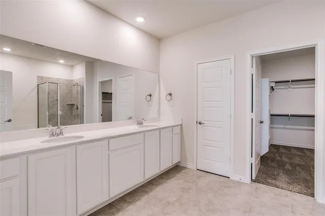 a spacious bathroom with a double vanity sink and a mirror