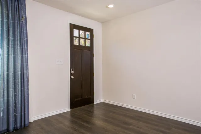 a view of an empty room with wooden floor and closet