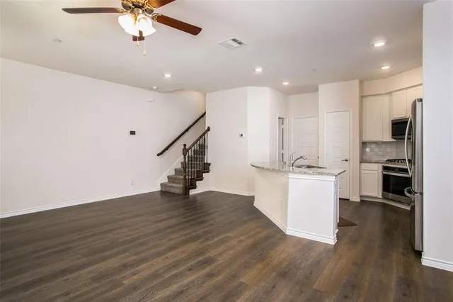 a view of kitchen with refrigerator microwave and stove